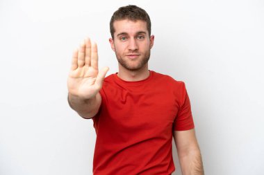 Beyaz arka planda izole edilmiş genç beyaz adam dur hareketi yapıyor.