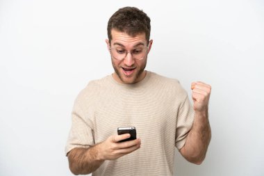 Beyaz arka planda izole genç beyaz adam şaşırdı ve bir mesaj gönderiyor