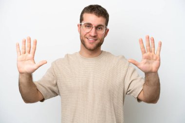 Beyaz arka planda izole edilmiş beyaz tenli genç adam parmaklarıyla ona kadar sayıyor.