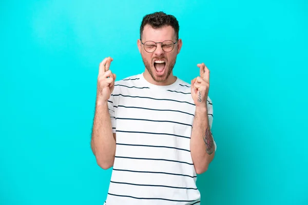 Young Brazilian Man Isolated Blue Background Fingers Crossing — ストック写真