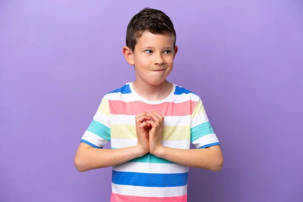 Niño Aislado Sobre Fondo Púrpura Maquinando Algo — Foto de Stock