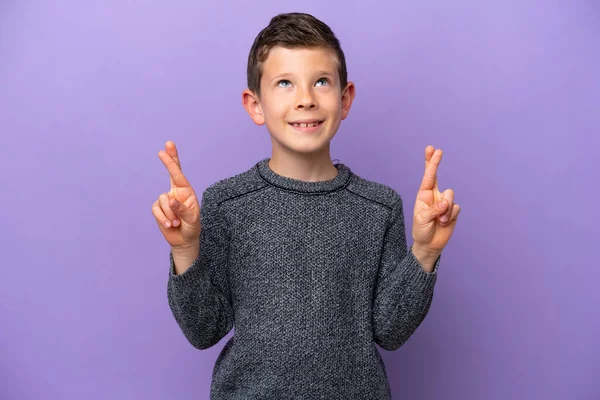 Küçük çocuk mor arka planda izole edilmiş, şans diliyor ve en iyisini diliyor.