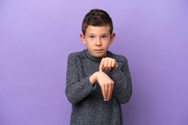 一个被紫色背景隔离的小男孩做了个迟到的手势 — 图库照片