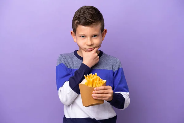 Menino Segurando Chips Fritos Isolados Fundo Roxo Pensando — Fotografia de Stock