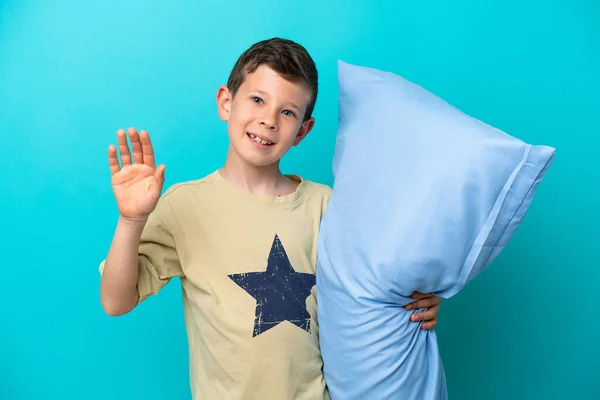 Mały Chłopiec Piżamie Odizolowany Niebieskim Tle Salutujący Ręką Szczęśliwym Wyrazem — Zdjęcie stockowe