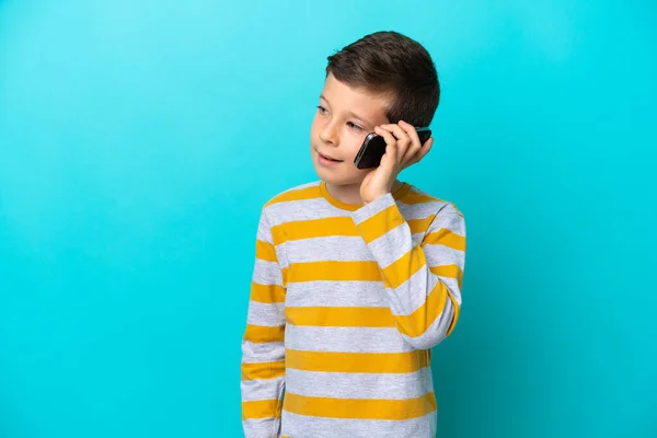 Niño Aislado Sobre Fondo Azul Manteniendo Una Conversación Con Teléfono —  Fotos de Stock