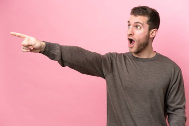 Pembe arka planda izole edilmiş genç beyaz adam...