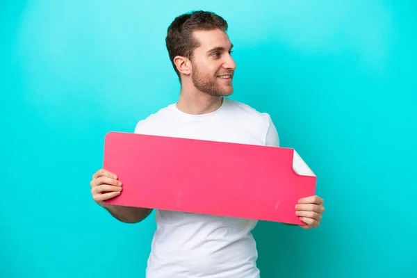 Young Caucasian Man Isolated Blue Background Holding Empty Placard Looking —  Fotos de Stock