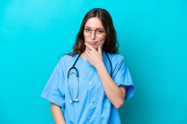 Genç cerrah kadın. Mavi arka planda izole edilmiş.