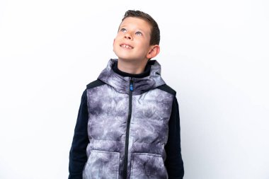 Beyaz arka planda izole edilmiş küçük bir çocuk yukarı bakarken bir fikir düşünüyor.