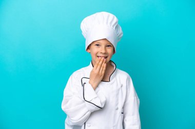 Küçük aşçı çocuk mavi arka planda izole edilmiş mutlu ve gülümsüyor.