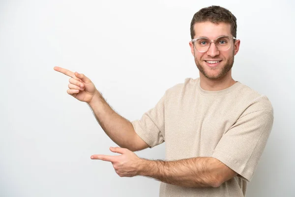 白い背景の指を横に向けて製品を提示する若い白人男性 — ストック写真