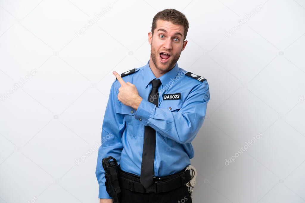 Young police caucasian man isolated on white background surprised and pointing side