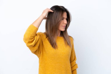 Beyaz arka planda soyutlanmış orta yaşlı beyaz bir kadın. Kafasını kaşırken şüpheleri var.