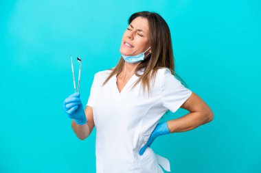 Orta yaşlı doktor kadın mavi arka planda izole edildi.