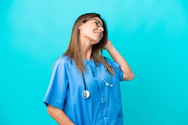 Orta yaşlı cerrah kadın mavi arka planda izole edilmiş bir fikir düşünüyor.