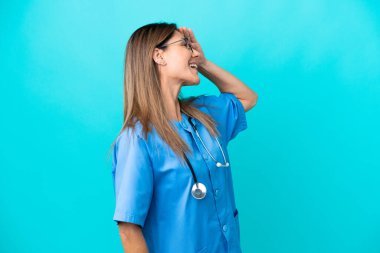 Mavi arka planda izole edilmiş orta yaşlı cerrah kadın bir şey fark etti ve çözümü arıyor.