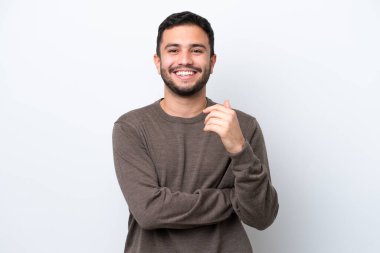 Genç Brezilyalı adam beyaz arka planda izole edilmiş gülüyor.