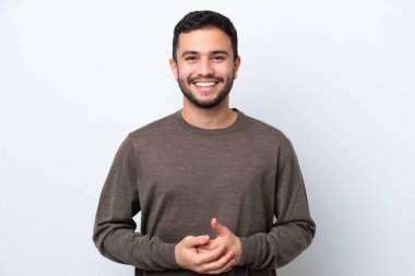 Genç Brezilyalı adam beyaz arka planda izole edilmiş gülüyor.