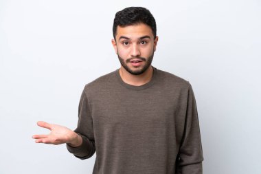 Beyaz arka planda izole edilmiş genç Brezilyalı adam şüpheli hareketler yapıyor.