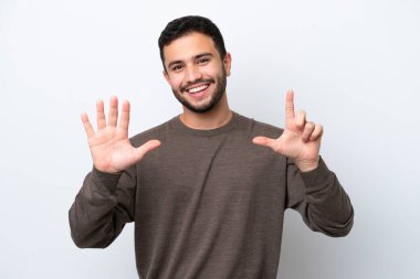 Beyaz arka planda izole edilmiş genç Brezilyalı adam yediyi parmaklarıyla sayıyor