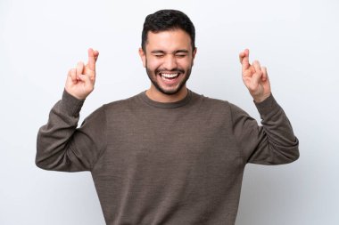 Genç Brezilyalı adam beyaz arka planda izole edilmiş ve şans diliyor.