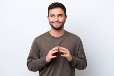 Genç Brezilyalı bir adam beyaz arka planda bir şeyler planlıyor.