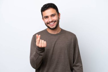 Beyaz arka planda izole genç Brezilyalı adam para hareketi yapıyor.