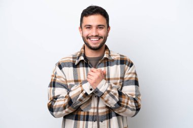 Genç Brezilyalı adam beyaz arka planda izole edilmiş gülüyor.