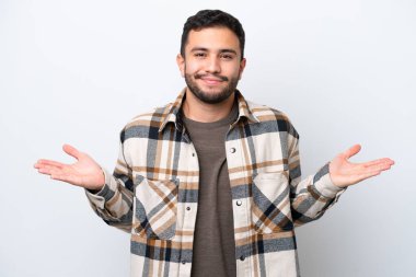 Genç Brezilyalı, beyaz arka planda izole edilmiş, şüphe duyan ve elini kaldıran bir adam.