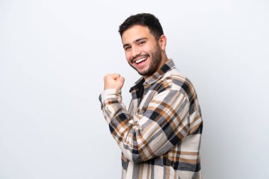 Genç Brezilyalı izole edilmiş beyaz arka planda zaferi kutluyor.