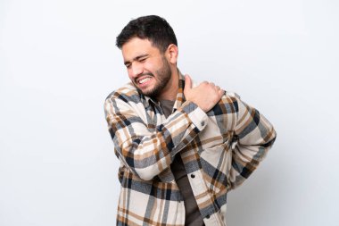 Genç Brezilyalı bir adam beyaz arka planda izole edilmiş, omuz ağrısından muzdarip, çabaladığı için