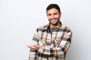 Genç Brezilyalı bir adam beyaz arka planda izole edilmiş bir fikir sunuyor.