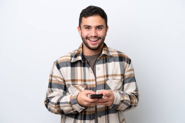 Beyaz arka planda izole edilmiş genç Brezilyalı bir adam şaşırdı ve bir mesaj gönderiyor.