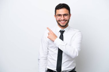 Beyaz arka planda izole edilmiş Brezilyalı bir adam bir ürün sunmak için kenarı işaret ediyor