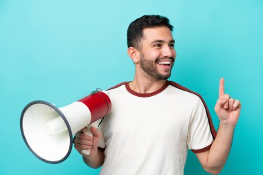 Mavi arka planda izole edilmiş genç Brezilyalı bir adam elinde bir megafonla çözümü bulmaya çalışıyor.