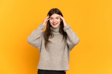 Sarı arka planda izole edilmiş genç Ukraynalı kız sürpriz bir ifadeyle