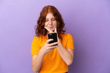 Mor geçmişi olan genç bir kızıl kız. Düşünüyor ve mesaj gönderiyor.