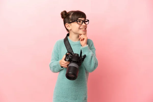 Pequeña Fotógrafa Aislada Sobre Fondo Rosa Pensando Una Idea Mientras —  Fotos de Stock