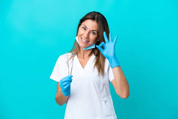 Middelbare Leeftijd Arts Vrouw Geïsoleerd Blauwe Achtergrond Tonen Teken Met — Stockfoto