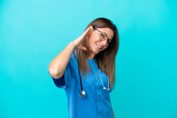 Chirurg Średnim Wieku Kobieta Odizolowana Niebieskim Tle Słuchając Czegoś Kładąc — Zdjęcie stockowe
