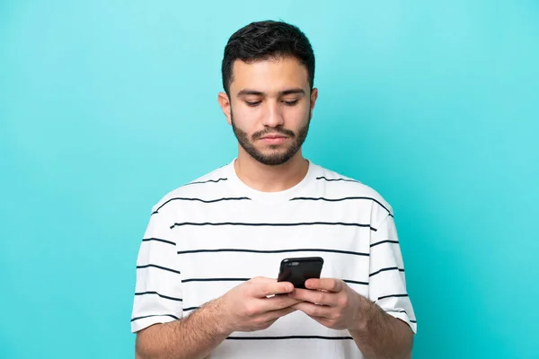 Young Brazilian Man Isolated Blue Background Using Mobile Phone — Stock Photo, Image