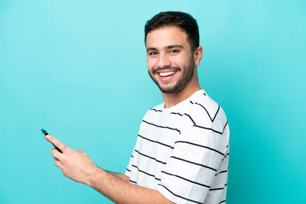 Genç Brezilyalı Adam Mavi Arkaplanda Izole Edilmiş Cep Telefonuyla Mesaj — Stok fotoğraf