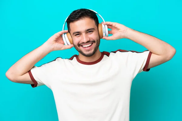 Νεαρός Βραζιλιάνος Απομονωμένος Μπλε Φόντο Ακούγοντας Μουσική — Φωτογραφία Αρχείου
