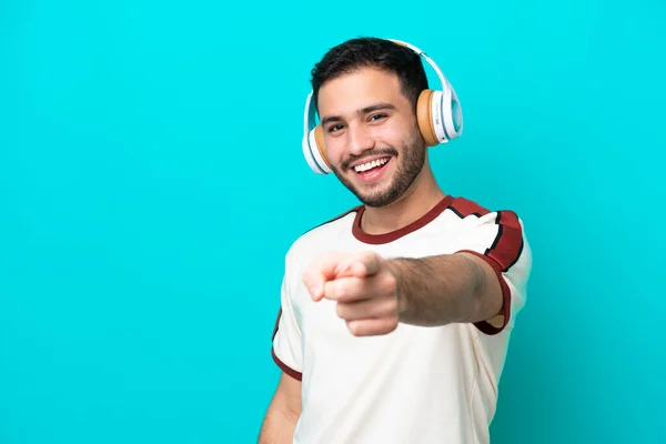 Jonge Braziliaanse Man Geïsoleerd Blauwe Achtergrond Luisteren Muziek Wijzen Naar — Stockfoto