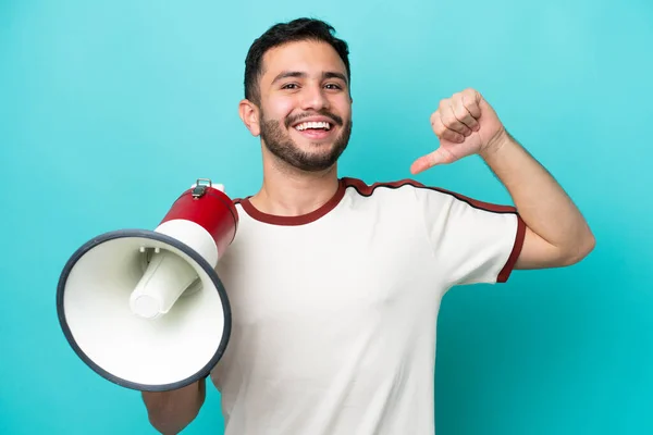 Jonge Braziliaanse Man Geïsoleerd Blauwe Achtergrond Met Een Megafoon Trots — Stockfoto