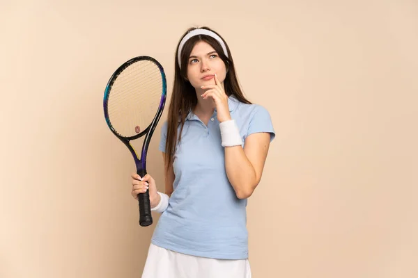 若いですウクライナの女の子テニス選手上の隔離された壁を持っています疑問ながら見上げます — ストック写真