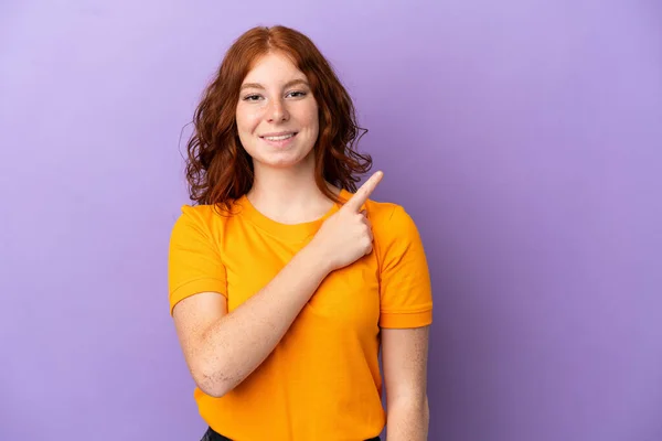 Adolescente Pelirroja Chica Sobre Aislado Púrpura Fondo Apuntando Lado Para — Foto de Stock