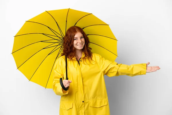 ティーネージャーRedhead女の子レインプルーフコートと傘孤立した上にホワイトバック拡張手に側への招待のために来る — ストック写真