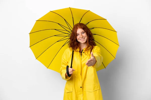 ティーンRedhead女の子雨防止コートと傘隔離上の白い背景揺れ手のために閉じますA良い取引 — ストック写真